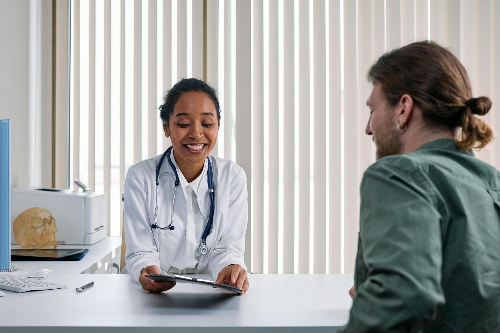 Junge Ärztin im Gespräch mit einem Patient